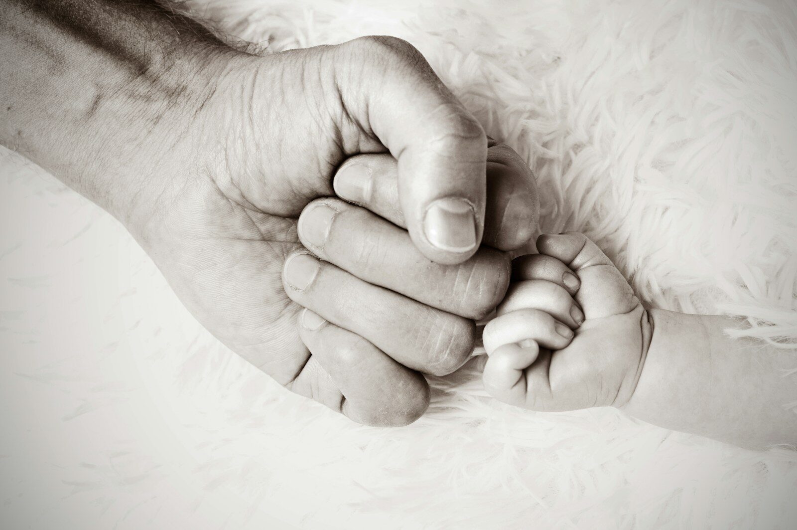 Photo by Heike Mintel a close up of a person holding a baby's hand